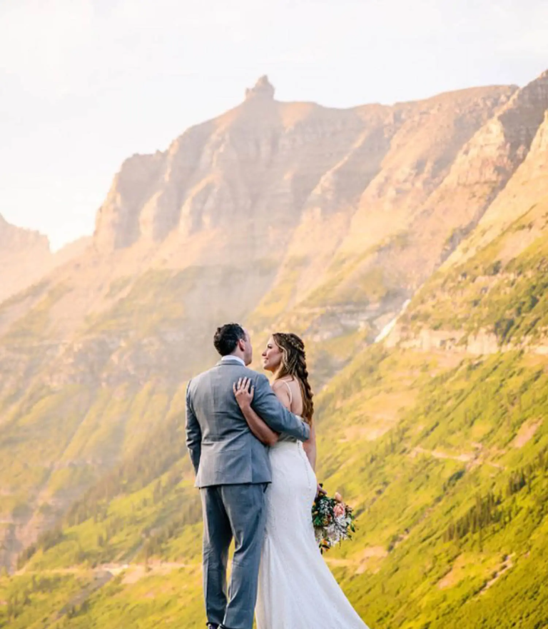Newlywed couple standing together with mountain landscape in background