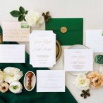 Emerald green wedding invitation suite with gold wax seal, calligraphy addressing, and ivory roses