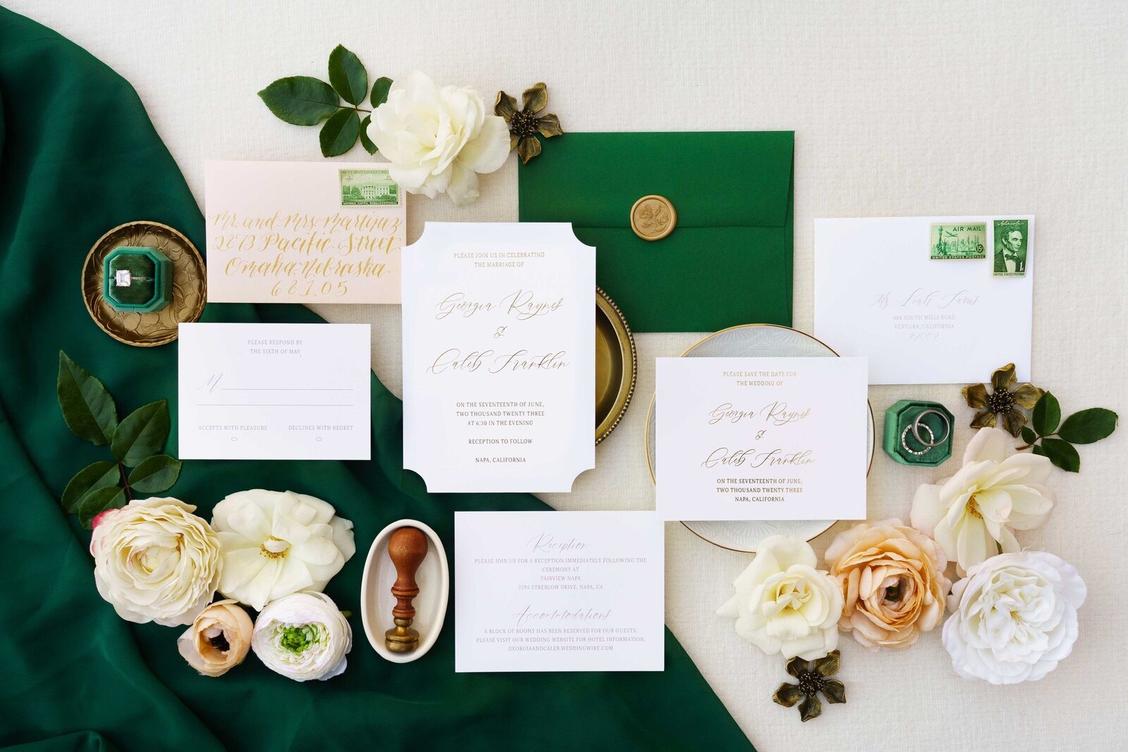 Emerald green wedding invitation suite with gold wax seal, calligraphy addressing, and ivory roses