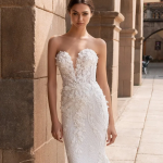 Bride wearing strapless beaded wedding dress with floral lace detailing in Mediterranean courtyard setting