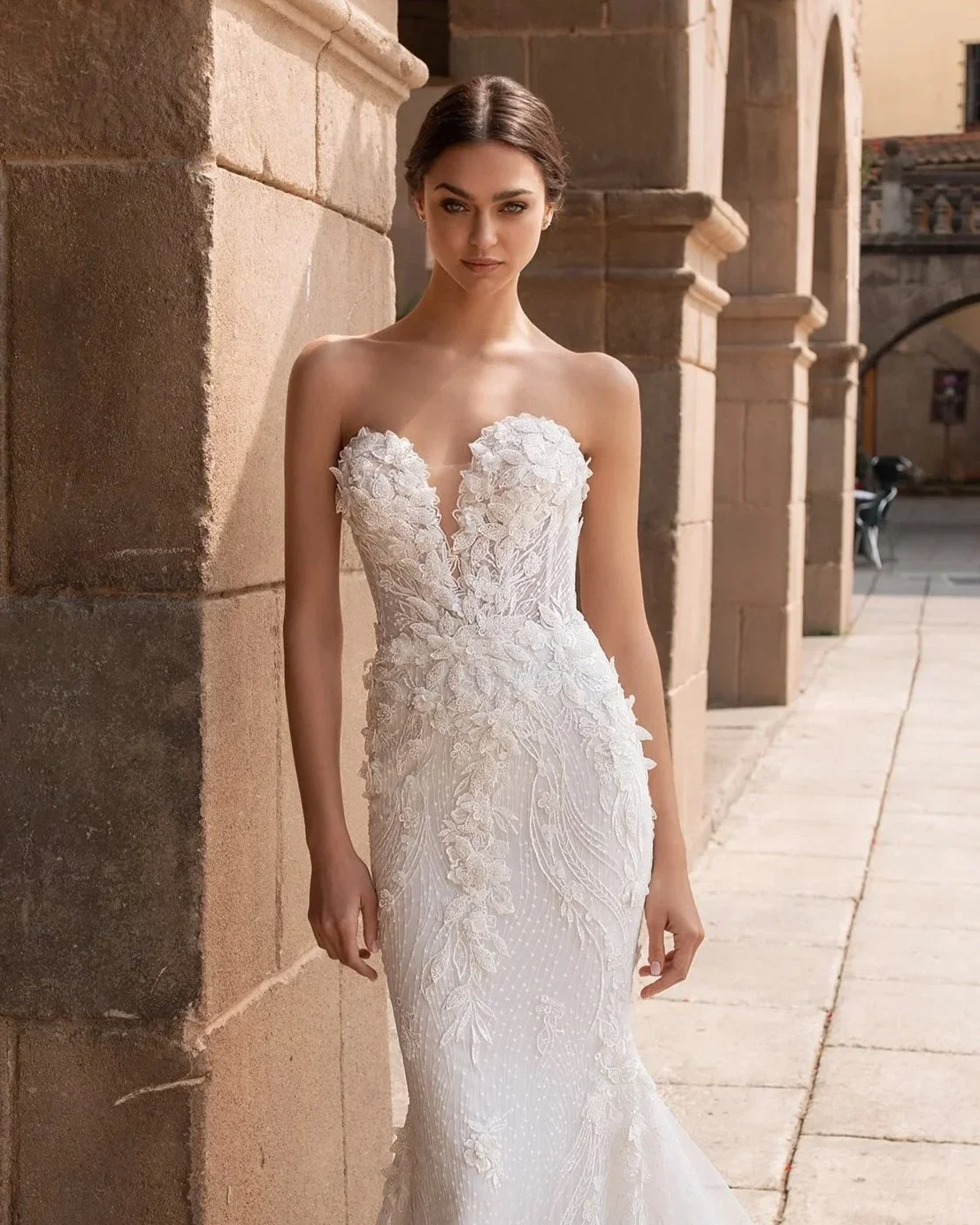 Bride wearing strapless beaded wedding dress with floral lace detailing in Mediterranean courtyard setting