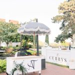 Custom wedding drink cart with navy monogram and matching beverage station in garden setting