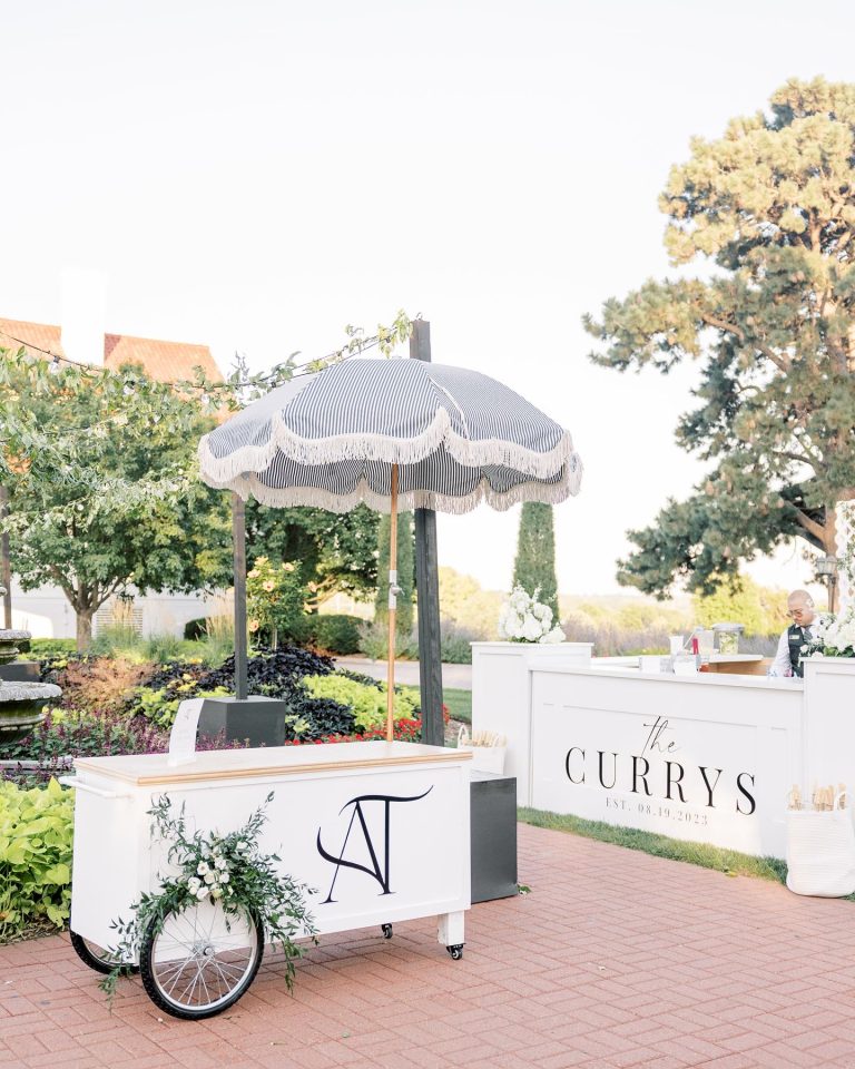 Custom wedding drink cart with navy monogram and matching beverage station in garden setting