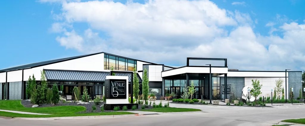 Modern white event venue building with manicured lawn in Nebraska