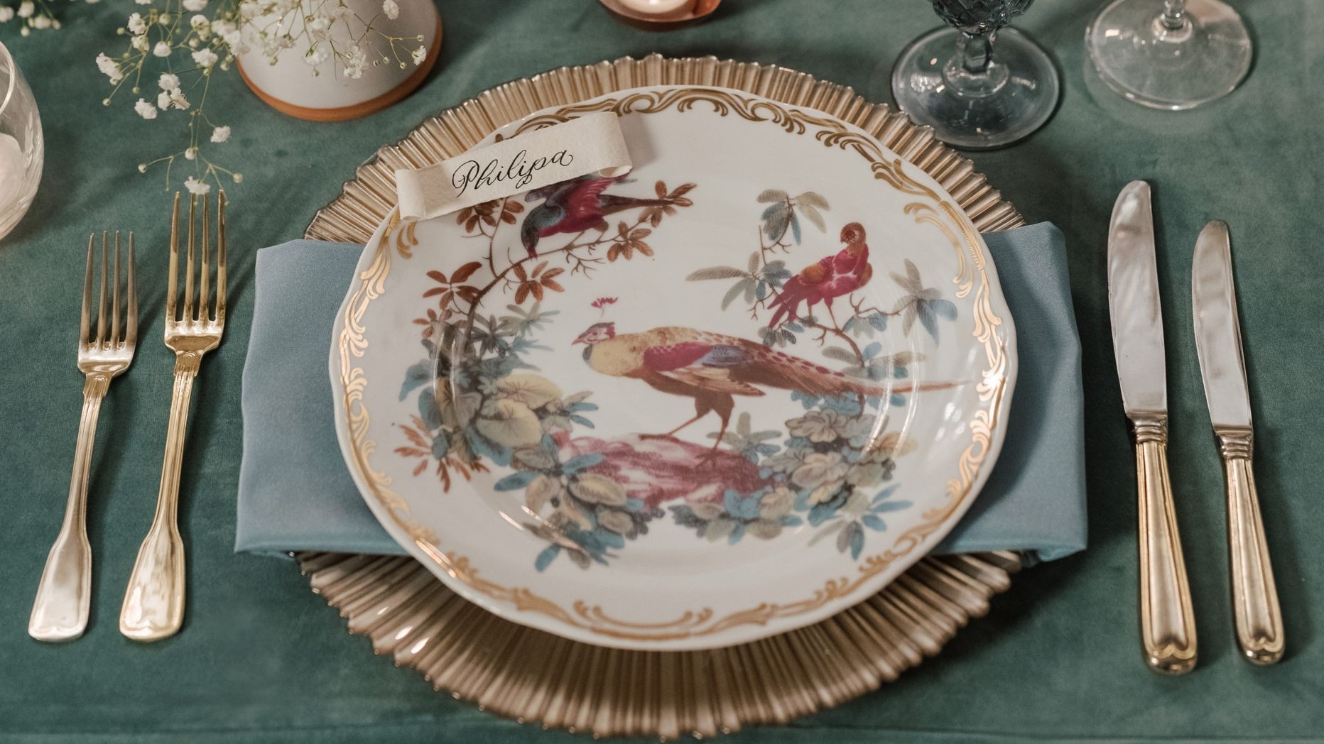 Vintage china plate with bird motif and calligraphy name card on formal table setting