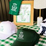 Custom Country Club themed wedding favors including embroidered caps, towels, and candles