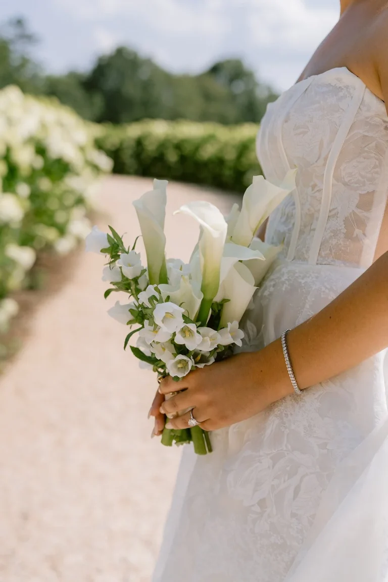 Bride holding white calla lily and orchid bouquet