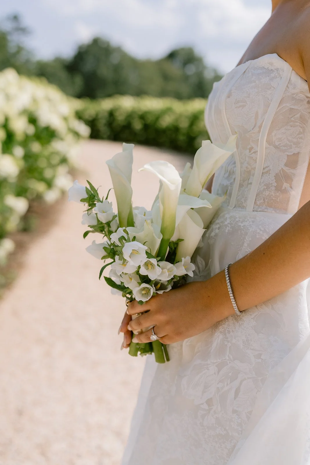Bride holding white calla lily and orchid bouquet