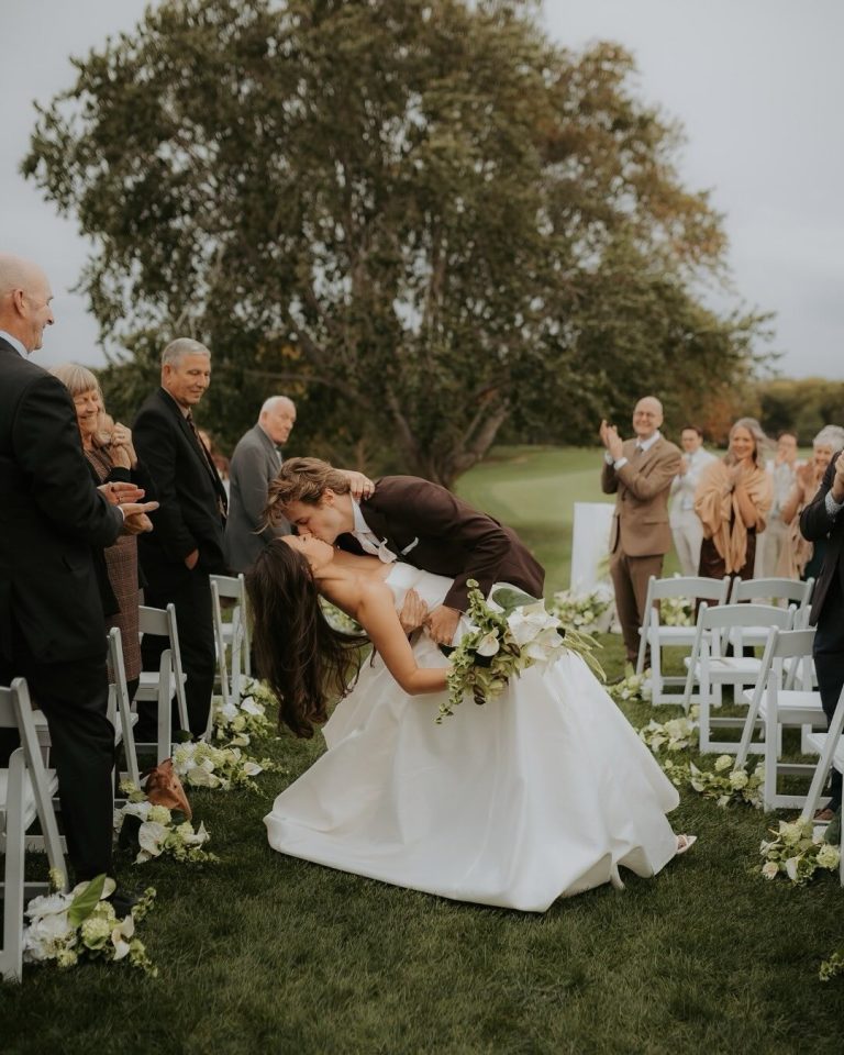 Bride and groom kiss during outdoor ceremony on Omaha Country Club grounds