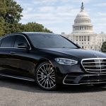 Black Mercedes-Benz S-Class luxury sedan with distinctive multi-spoke wheels in front of U.S. Capitol