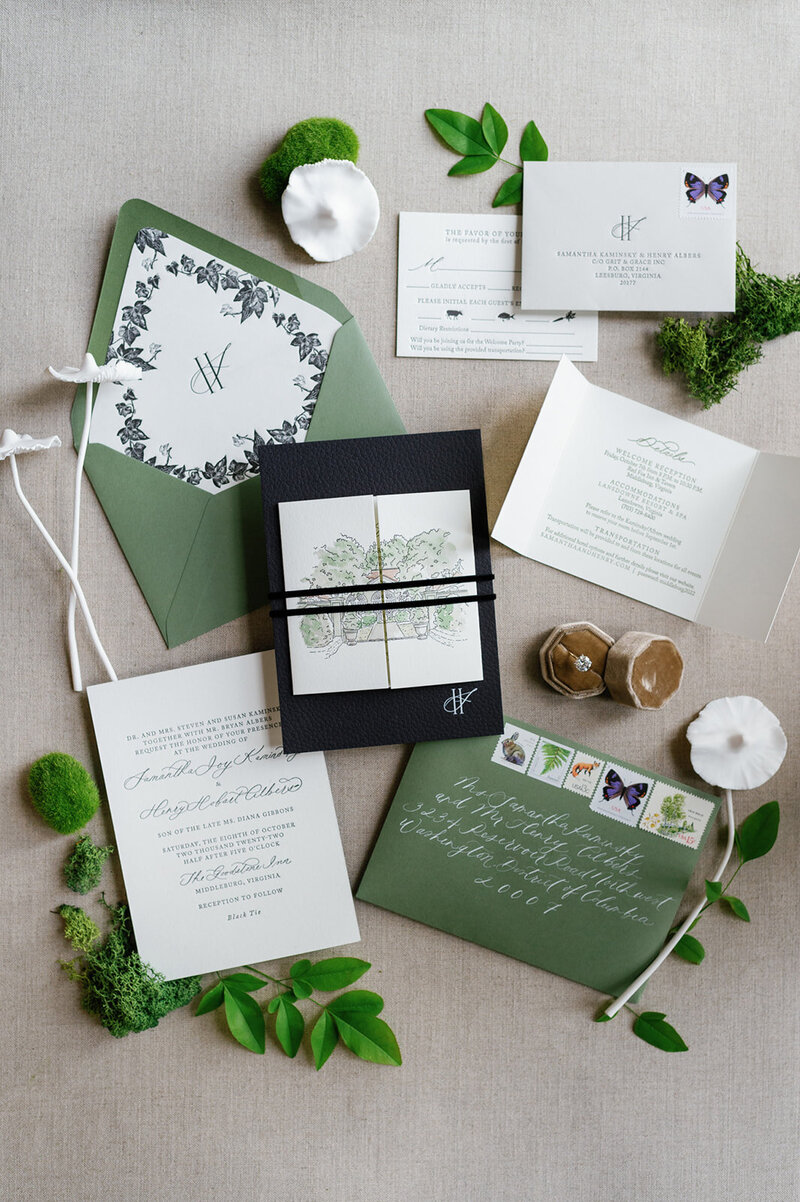 Elegant wedding invitation suite in green and navy with botanical details, calligraphy, and moss accents