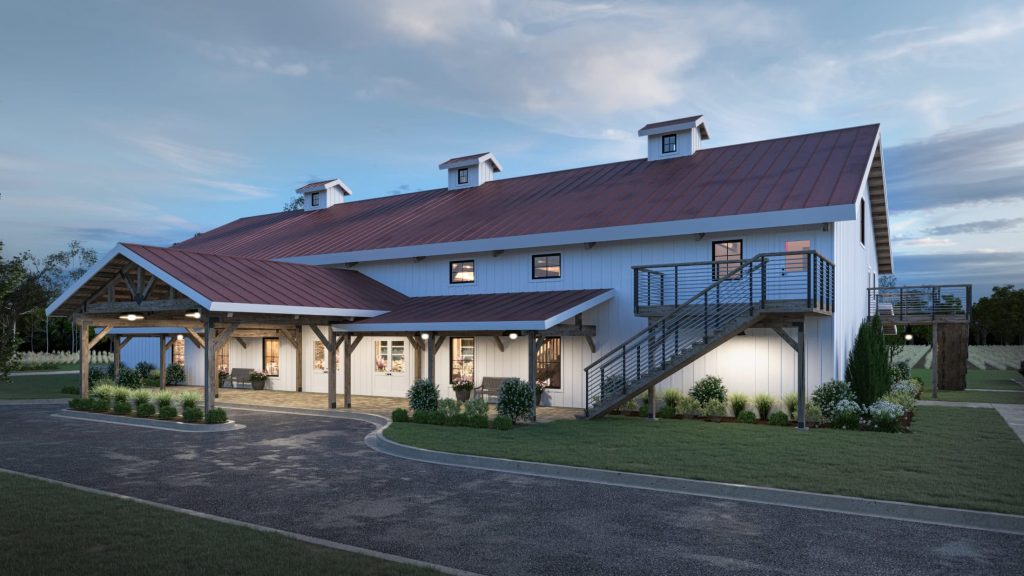 Modern white barn wedding venue with red metal roof, covered porch, exterior staircase, and landscaped grounds at dusk