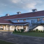 Modern white barn wedding venue with red metal roof, covered porch, exterior staircase, and landscaped grounds at dusk