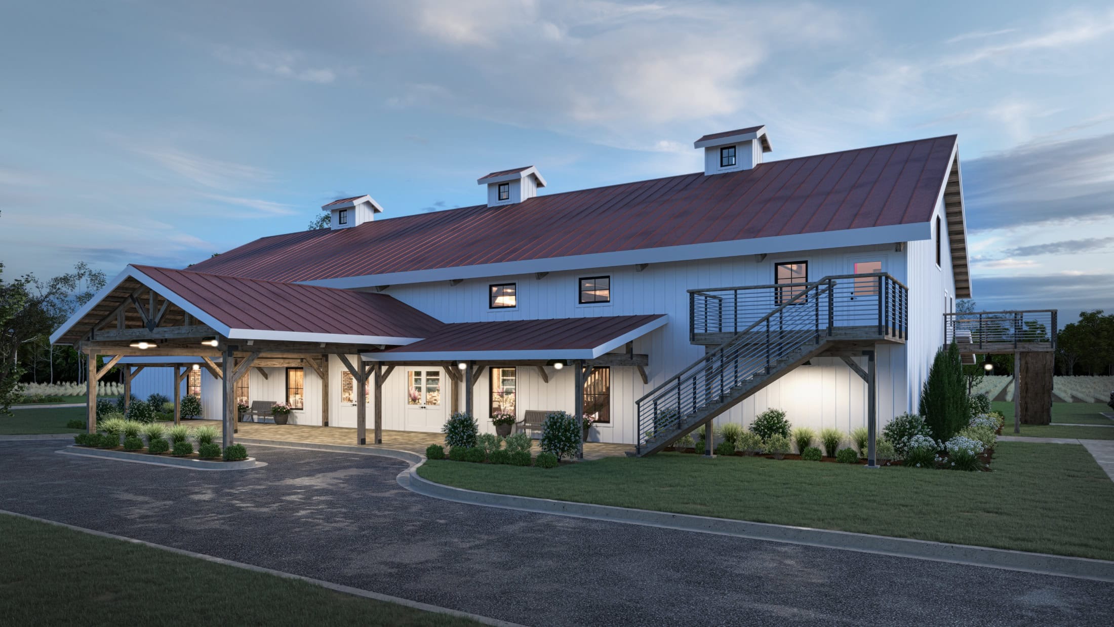 Modern white barn wedding venue with red metal roof, covered porch, exterior staircase, and landscaped grounds at dusk