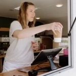 Barista making specialty coffee drinks at mobile catering truck