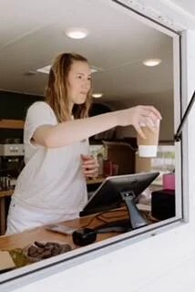 Barista making specialty coffee drinks at mobile catering truck
