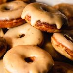Stack of glazed donuts with chocolate chips and vanilla icing
