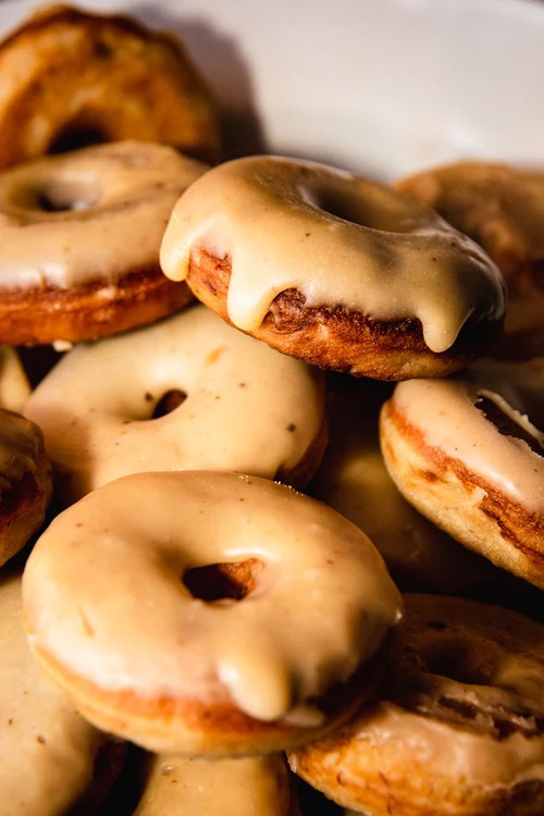 Stack of glazed donuts with chocolate chips and vanilla icing