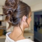 Romantic twisted bridal updo with face-framing pieces and textured bun