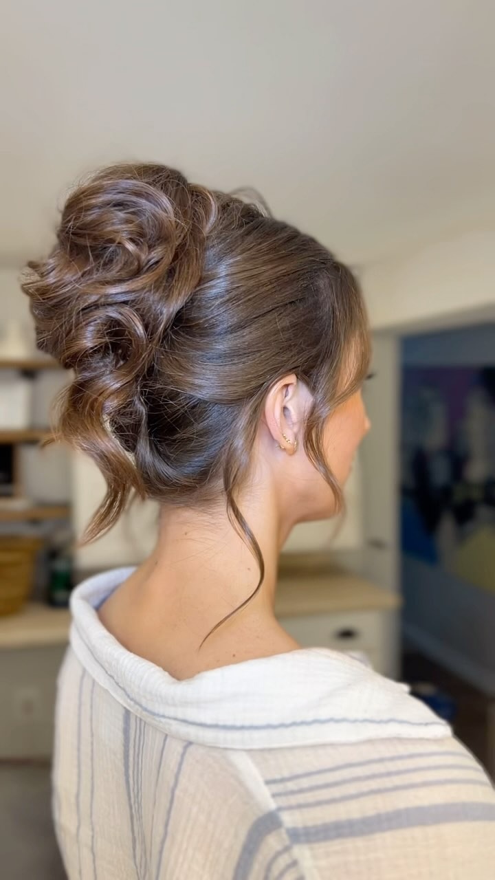 Romantic twisted bridal updo with face-framing pieces and textured bun