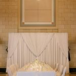 Elegant wedding reception table with white linens, candles, and floral centerpiece under chandelier in historic Nebraska venue