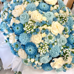 Wedding cupcake arrangement featuring buttercream flowers in blue and ivory creating a floral bouquet design