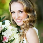 Bride with vintage-inspired Hollywood waves, natural makeup, and white rose bouquet