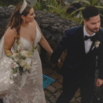Bride and groom walking together on stone pathway outdoors