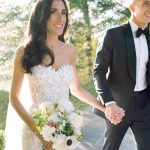 Bride and groom holding hands outdoors in sunny Northern Virginia garden setting