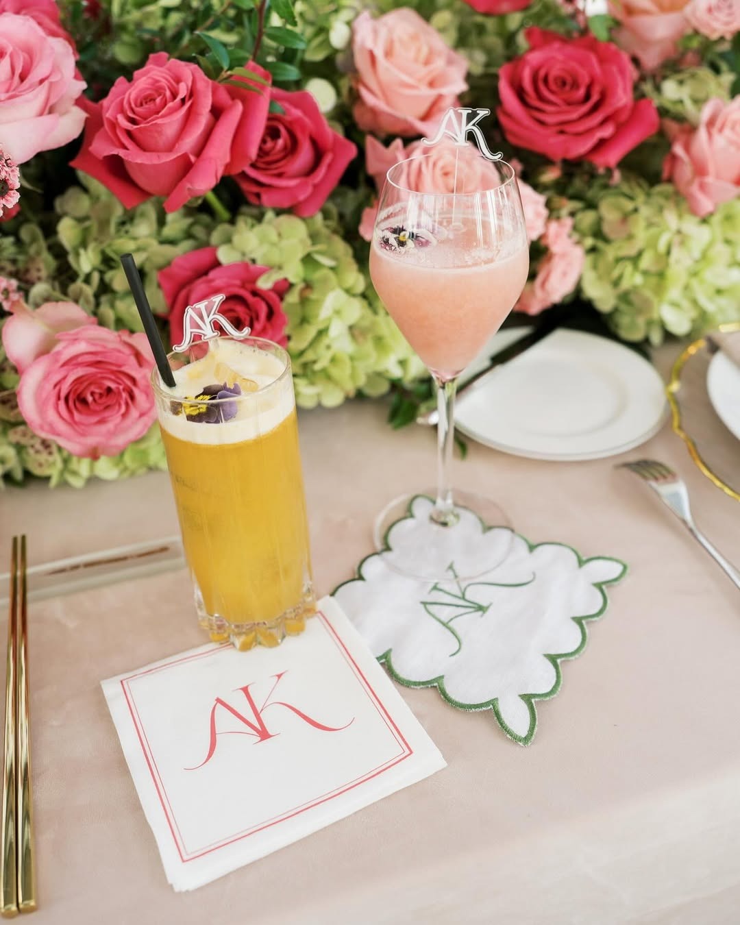 Custom monogrammed napkins and coasters displayed with fresh pink roses and cocktails