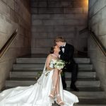 Bride and groom kissing on staircase in modern architectural setting