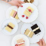 Overhead flat lay of five layered cake slices in various flavors including chocolate, vanilla, and strawberry