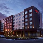 The Scarlet Hotel modern exterior at dusk with illuminated windows and landscaped entrance