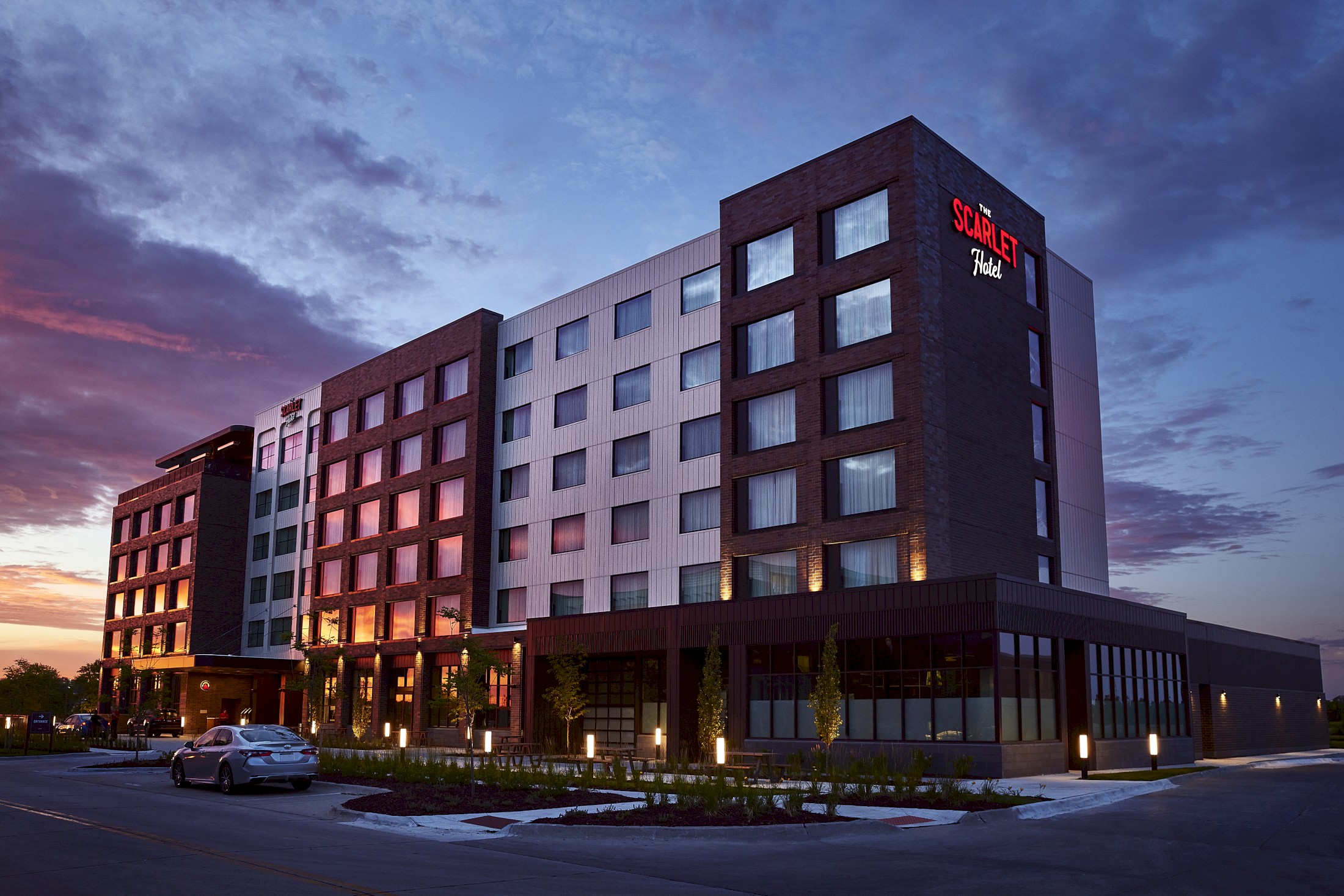 The Scarlet Hotel modern exterior at dusk with illuminated windows and landscaped entrance