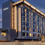 Modern Hilton hotel exterior at twilight with illuminated windows in Alpharetta