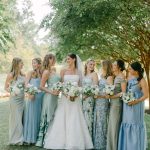 Bride and bridesmaids laughing together under tree in garden setting at Salamander Resort