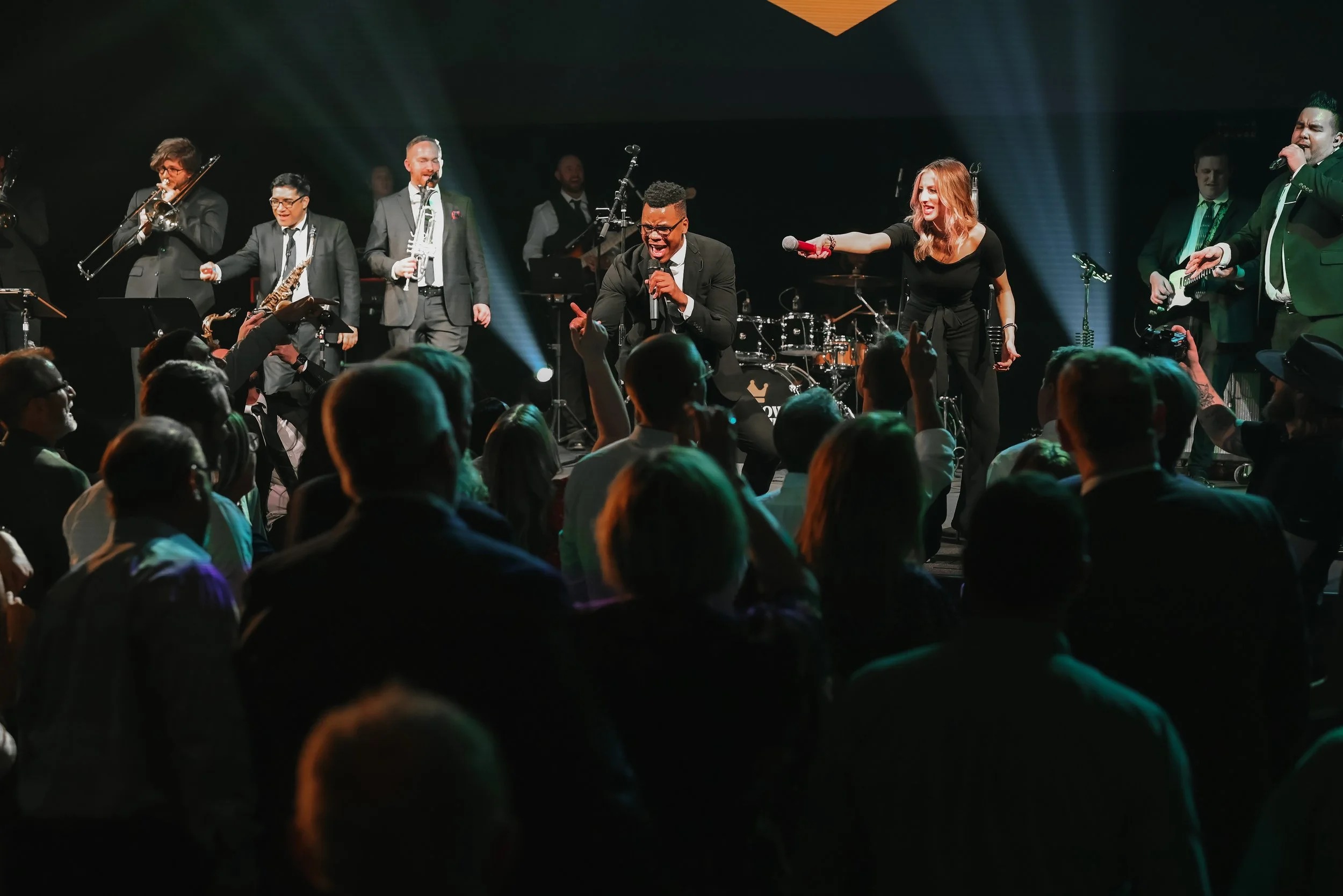 Downtown Collective band performing for enthusiastic wedding reception crowd with horn section and vocalist