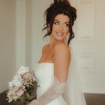 Bride with sophisticated wedding beauty look featuring loose updo and luminous makeup