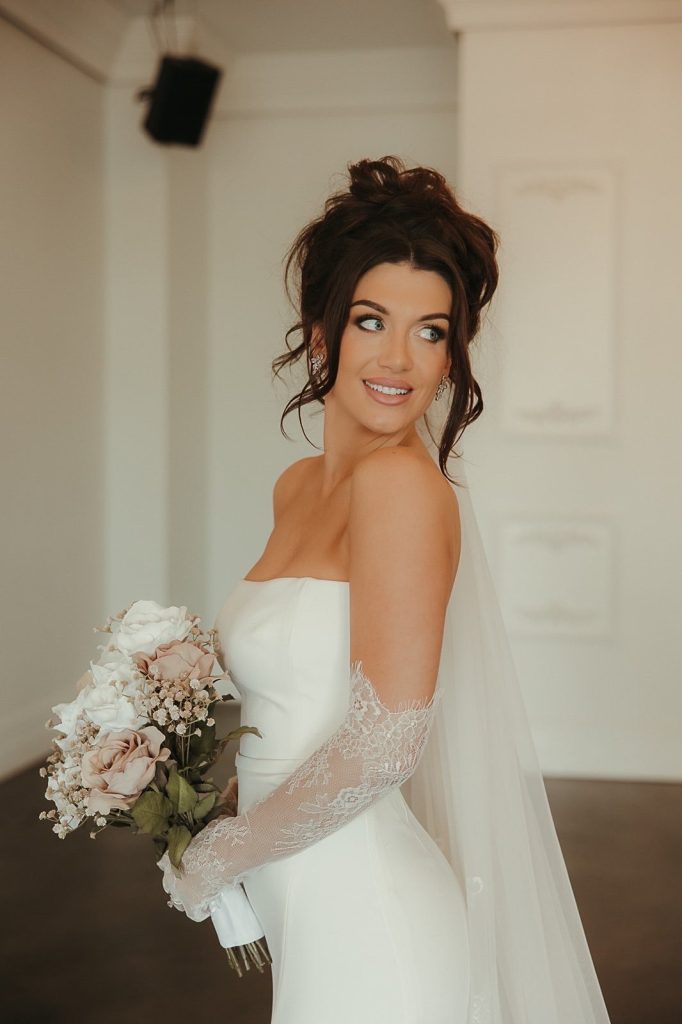 Bride with sophisticated wedding beauty look featuring loose updo and luminous makeup