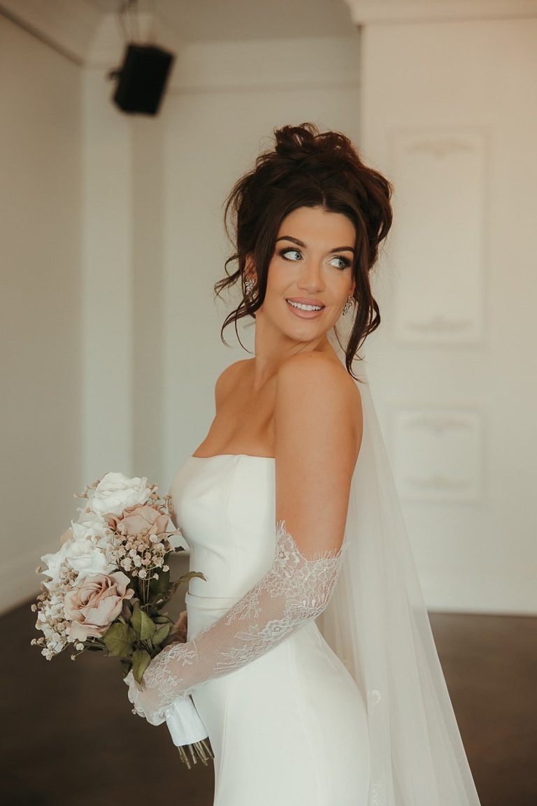 Bride with sophisticated wedding beauty look featuring loose updo and luminous makeup