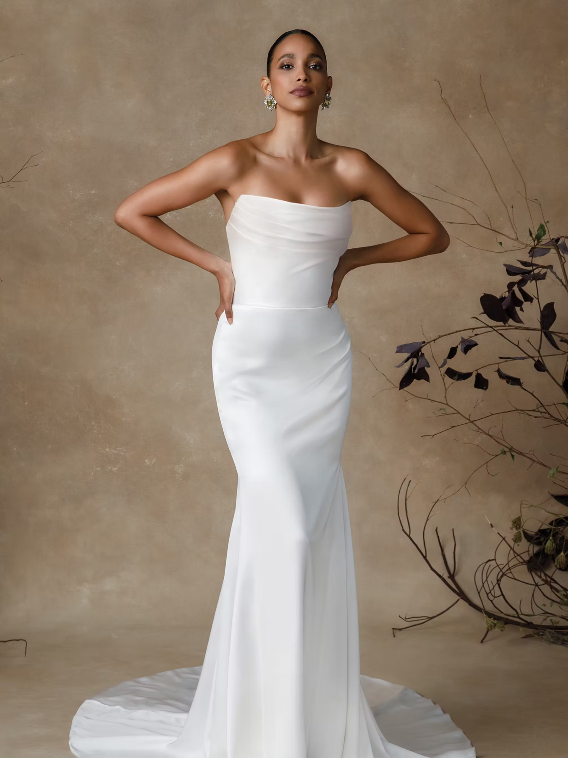 Model in elegant strapless mermaid wedding gown with sweetheart neckline and chapel train