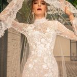 Close-up of bride in sheer lace wedding dress with high neckline and long sleeves