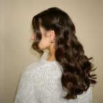 Long brunette hair styled in loose, voluminous curls cascading down the back