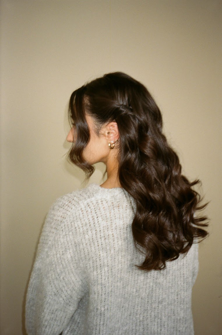 Long brunette hair styled in loose, voluminous curls cascading down the back