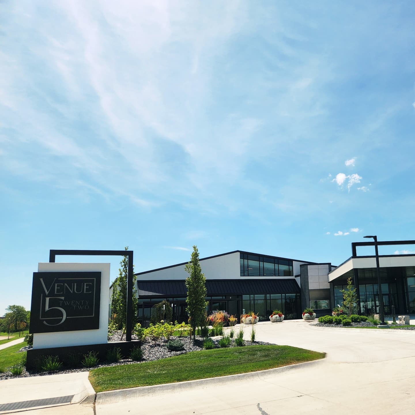 Modern black and white exterior of Venue 5 Twenty-Two with landscaping and entrance sign