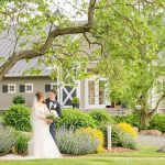 bride and groom posing in front of winery doors