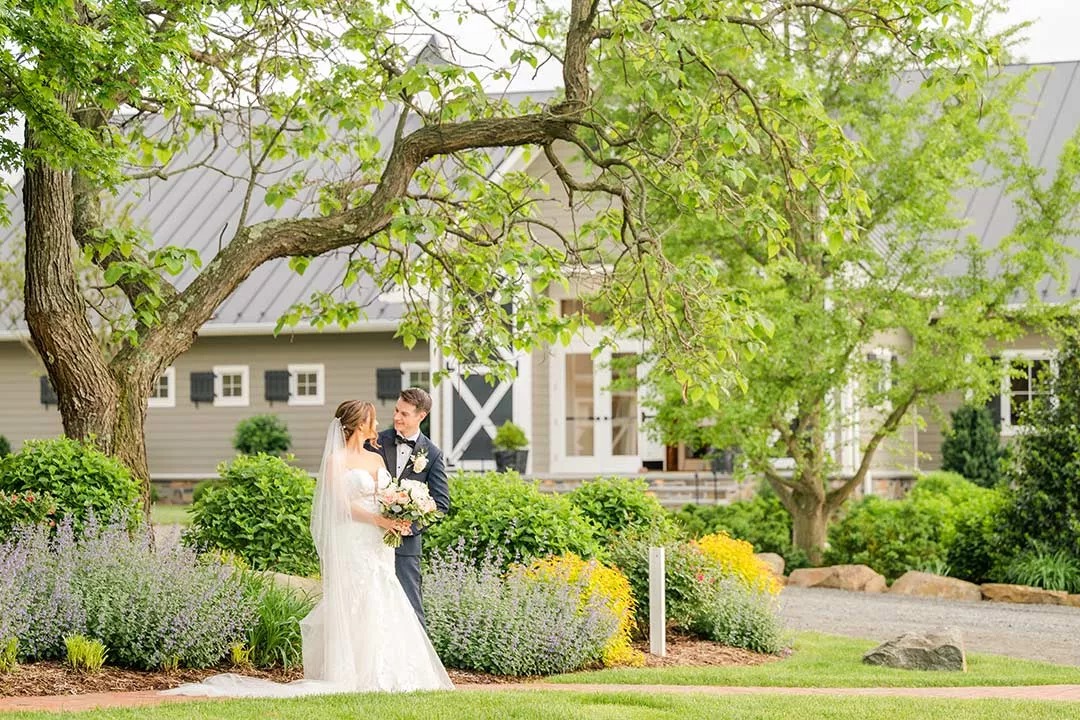 bride and groom posing in front of winery doors