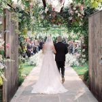 Dad and daughter walking down wedding aisle in garden outdoor setting