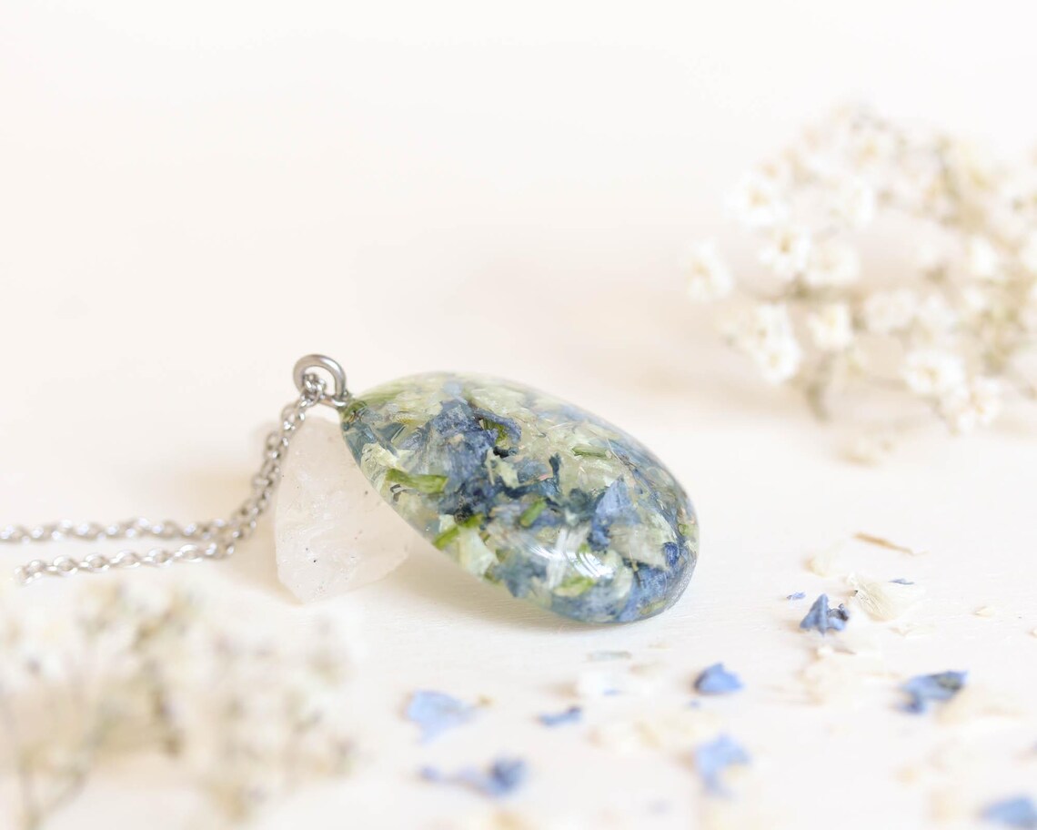 Teardrop pendant necklace containing preserved blue wedding flowers in clear resin