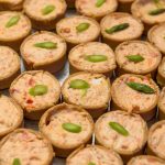 Savory mini quiches topped with jalapeño slices on catering tray